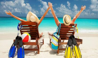 a couple of people sitting in chairs on a beach