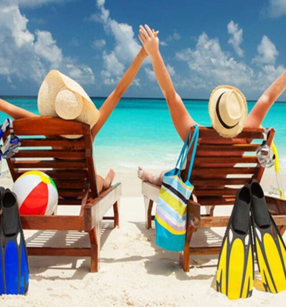a couple of people sitting in chairs on a beach