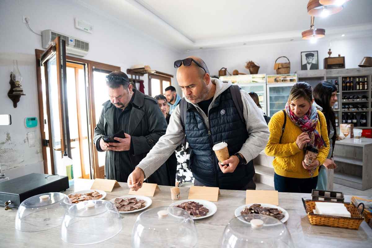 a group of people standing around a table with food