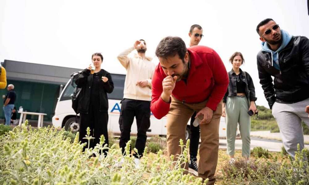 a group of people standing around a table with food