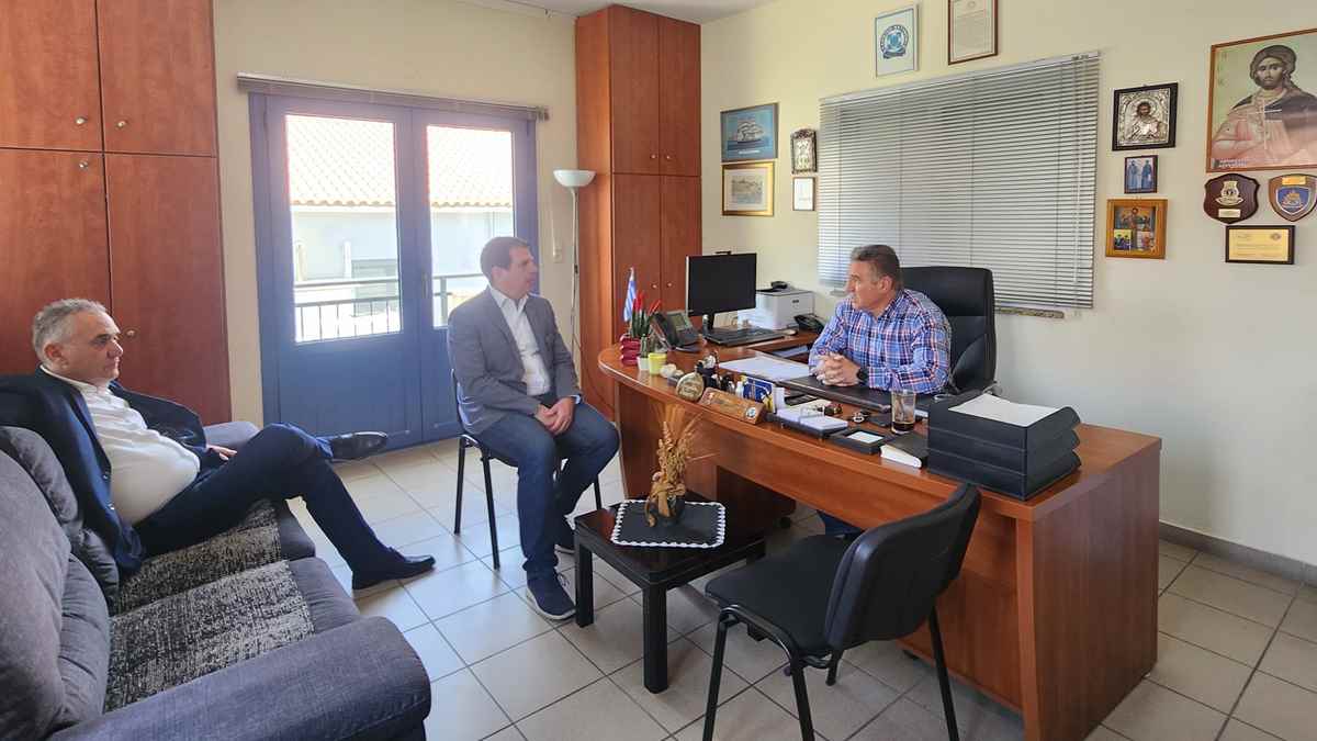 a group of men sitting at a desk in an office