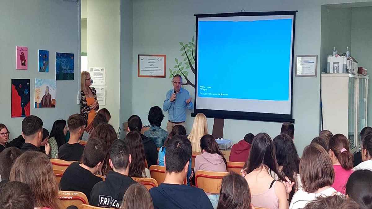 a man standing in front of a large screen