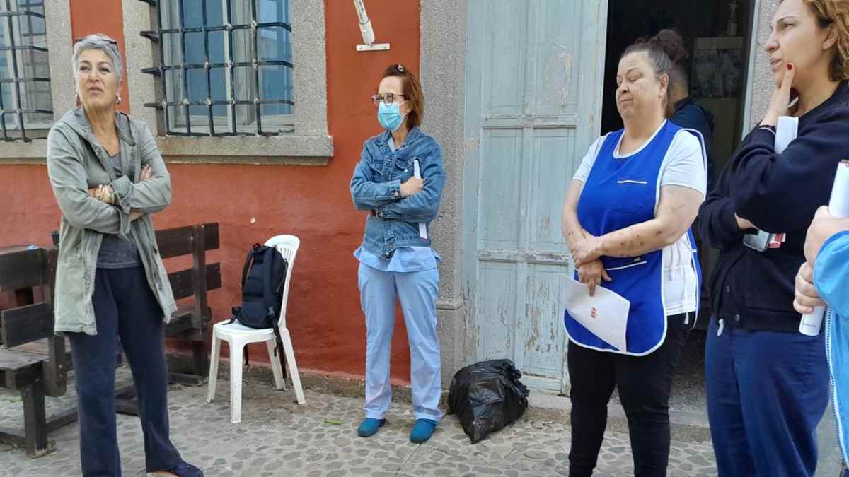 a woman standing next to a woman wearing a face mask