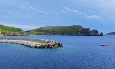 a rocky island with a hill in the background