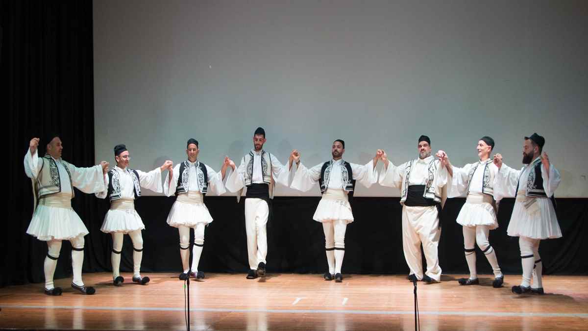 a group of men in white clothing on a stage