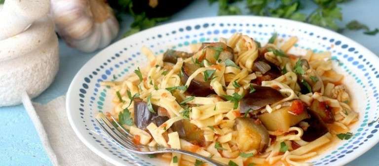 a plate of pasta with eggplant and parsley