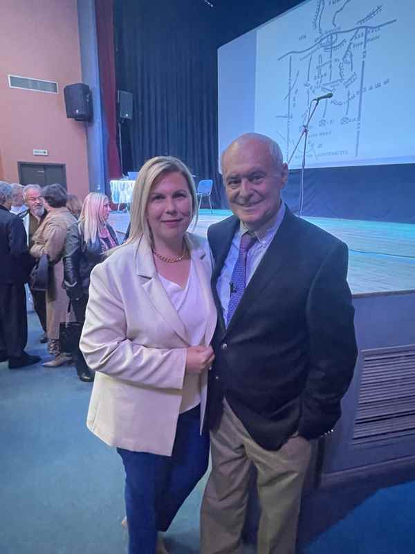 a man and woman standing together in front of a stage