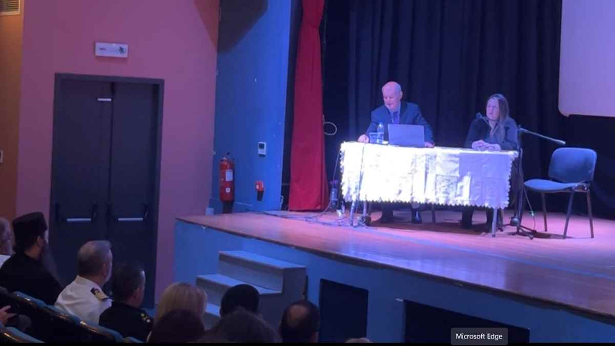a man on a stage with a laptop on a table