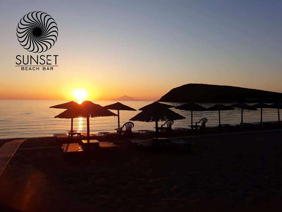 a glass of lemonade with a straw and lemon wedges