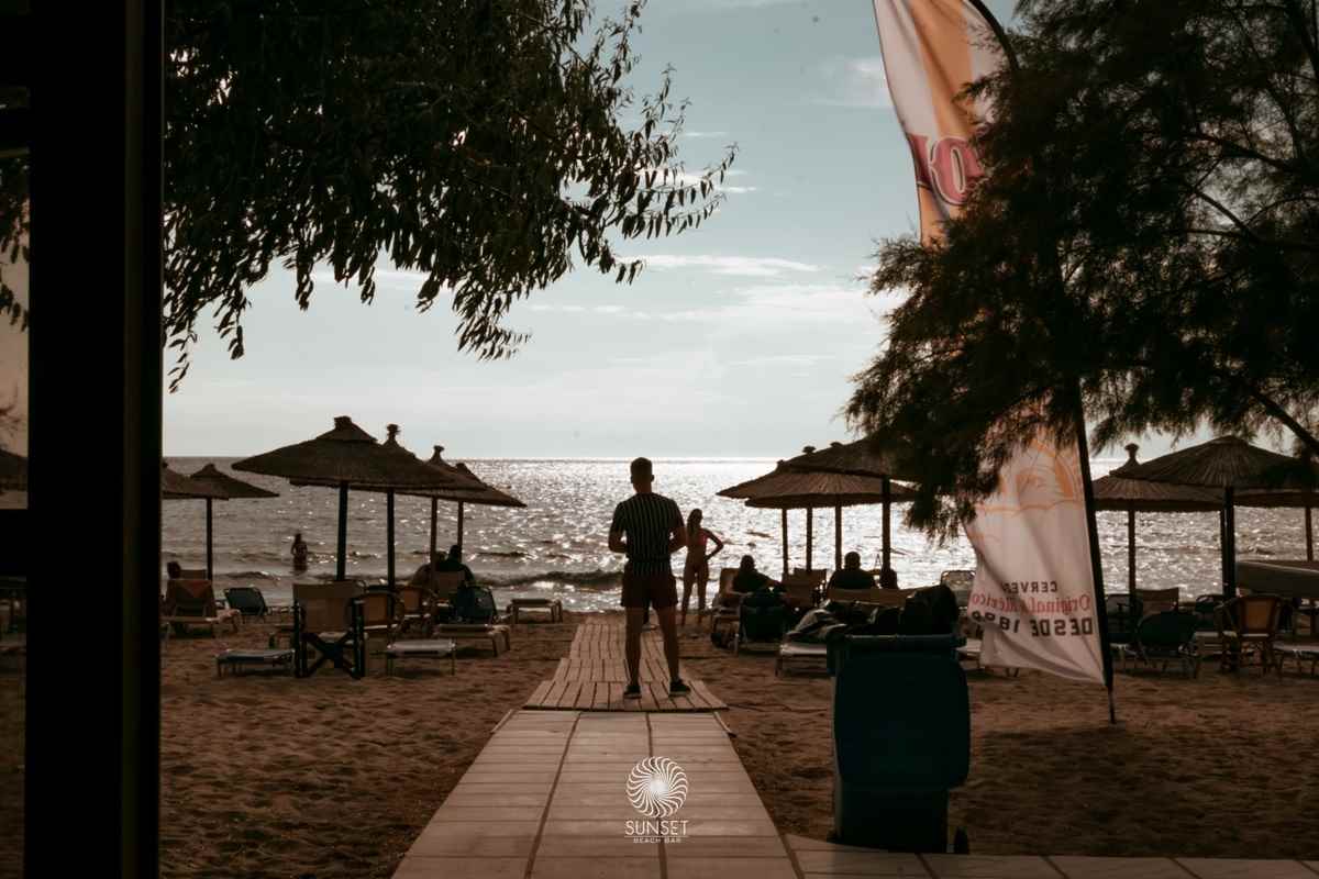 a group of people sitting on a beach with umbrellas