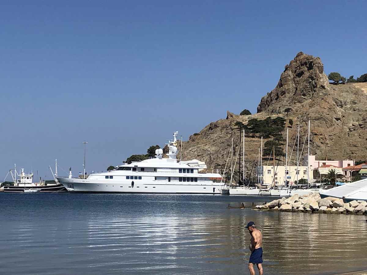 a man standing in water next to a large white boat