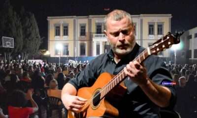a man playing a guitar in front of a crowd of people