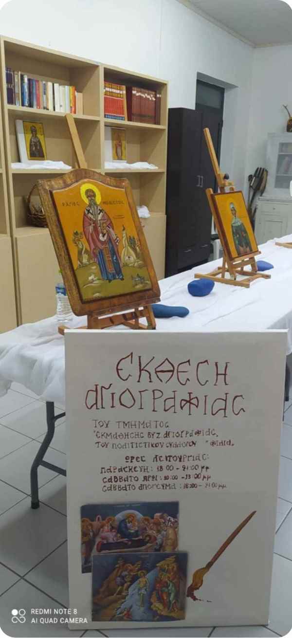 a table with a sign and paintings on it