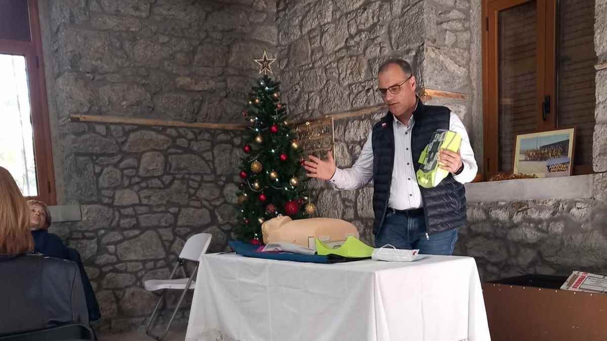 a man standing next to a christmas tree