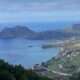 a landscape of a body of water with a town and mountains