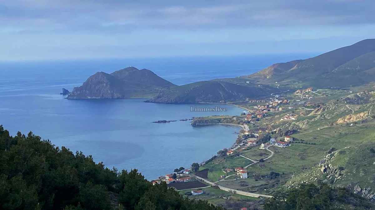 a landscape of a body of water with a town and mountains