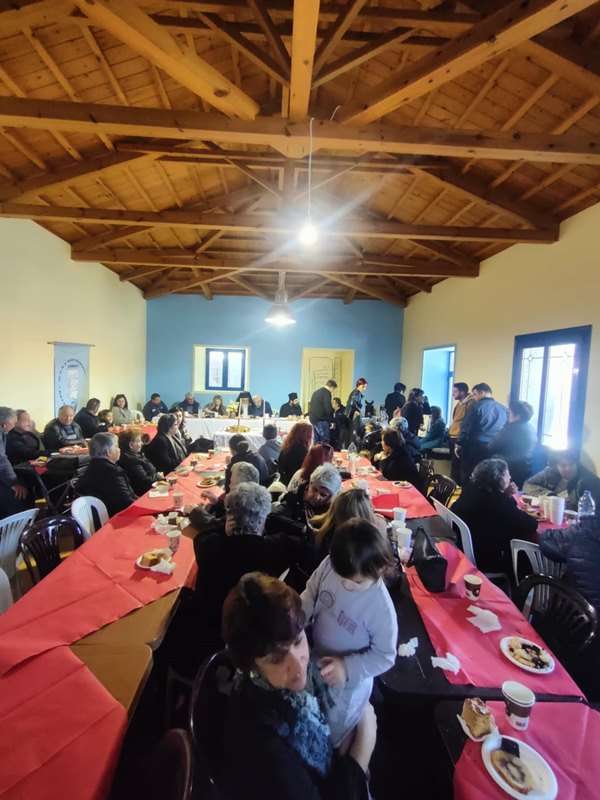 a group of people sitting at tables in a room with red tablecloths