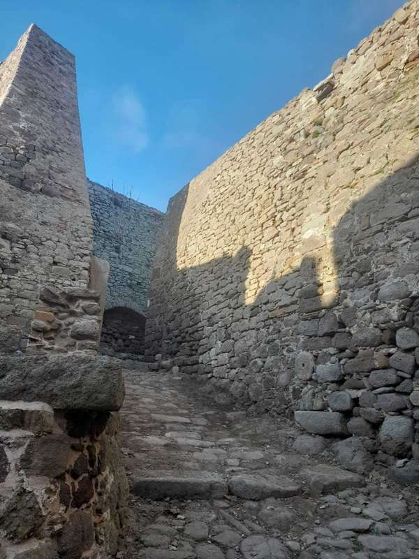 a stone wall with a stone staircase with Great Zimbabwe in the background
