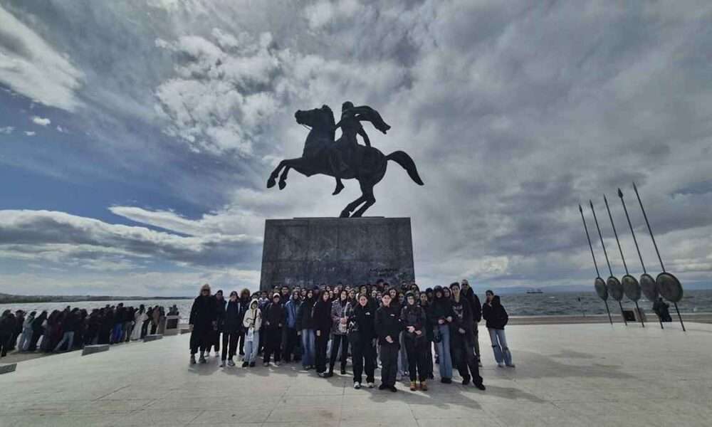 Ομάδα ανθρώπων μπροστά σε άγαλμα.