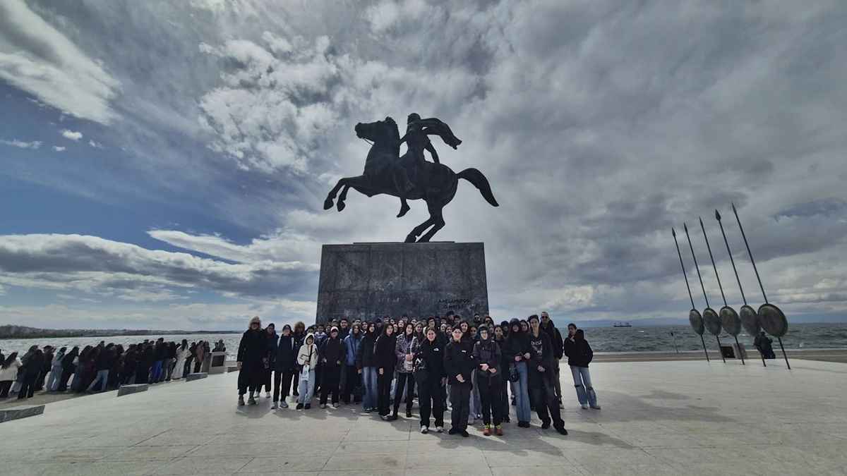Ομάδα ανθρώπων μπροστά σε άγαλμα.
